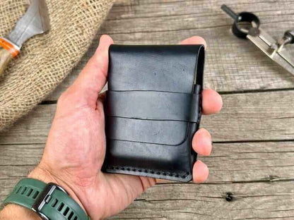 A hand holding a minimalist genuine leather wallet, showcasing its sleek design and premium material.