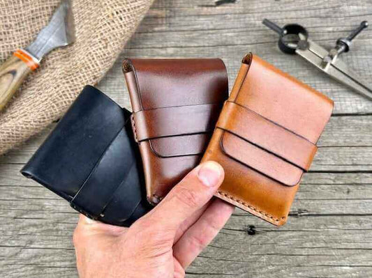 Three minimalist genuine leather wallets in hand, showcasing various color options, perfect for a stylish minimalist lifestyle.