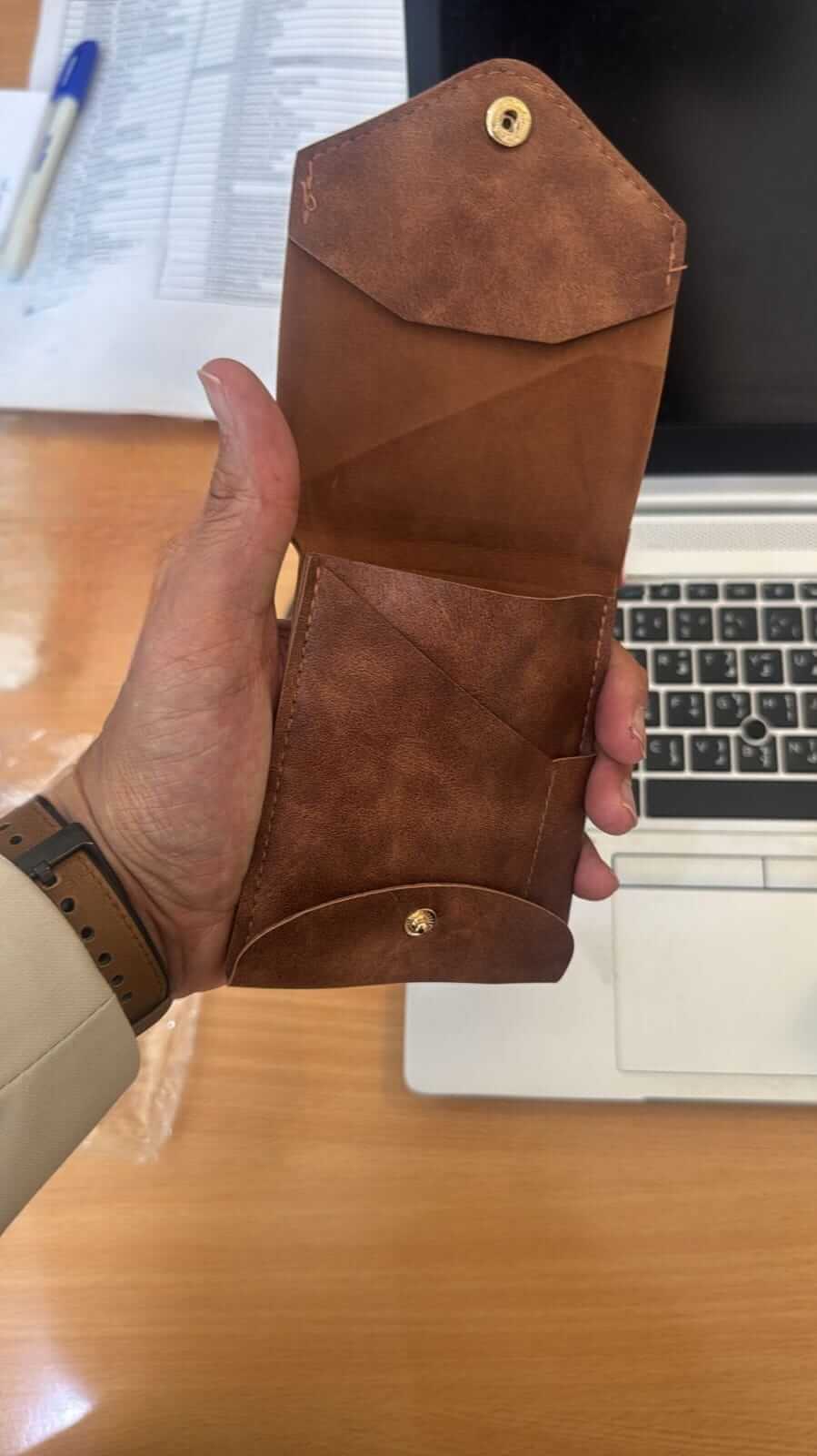 compact leather wallet with pen held open, showcasing pockets and premium leather craftsmanship.
