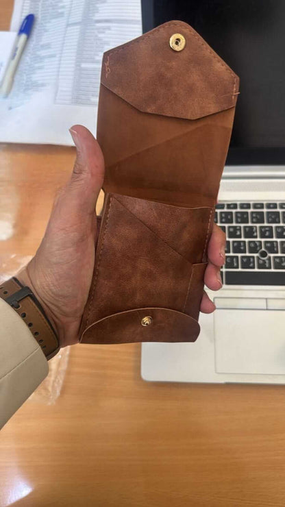 compact leather wallet with pen held open, showcasing pockets and premium leather craftsmanship.