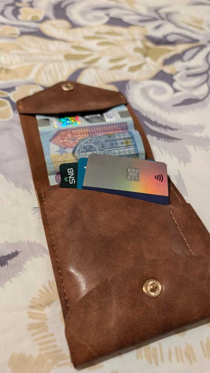 compact leather wallet with pen open, showing cash and cards inside for easy access and organization.